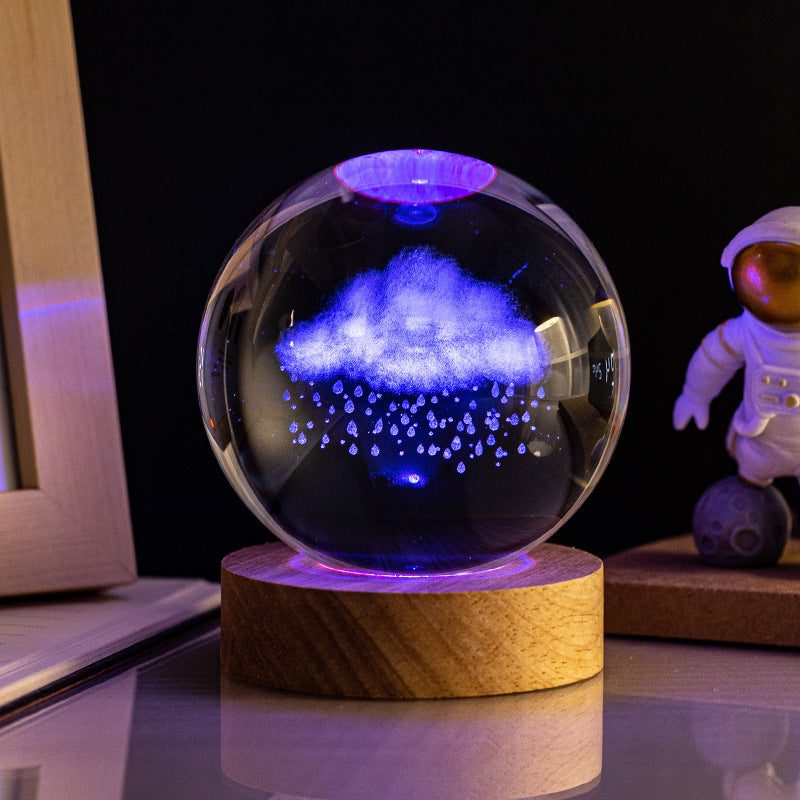 Créez une ambiance apaisante avec la lampe SpaceWood Nuage qui pleut. Inspirée par la beauté de la nature, cette lampe projette des couleurs douces et changeantes à travers une sphère en verre unique. Elle est parfaite pour un coin lecture ou une chambre, offrant une lumière relaxante et harmonieuse.