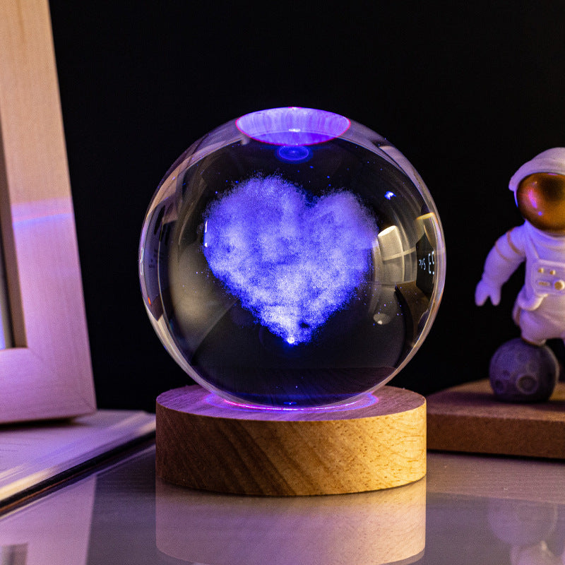 Apportez de l’amour et de la lumière dans votre espace avec la lampe SpaceWood Cœur. Sa lumière changeante traverse une sphère en verre ornée d’un motif en forme de cœur. Ce modèle unique s’associe parfaitement avec des intérieurs romantiques et modernes, créant une ambiance chaleureuse et intime.